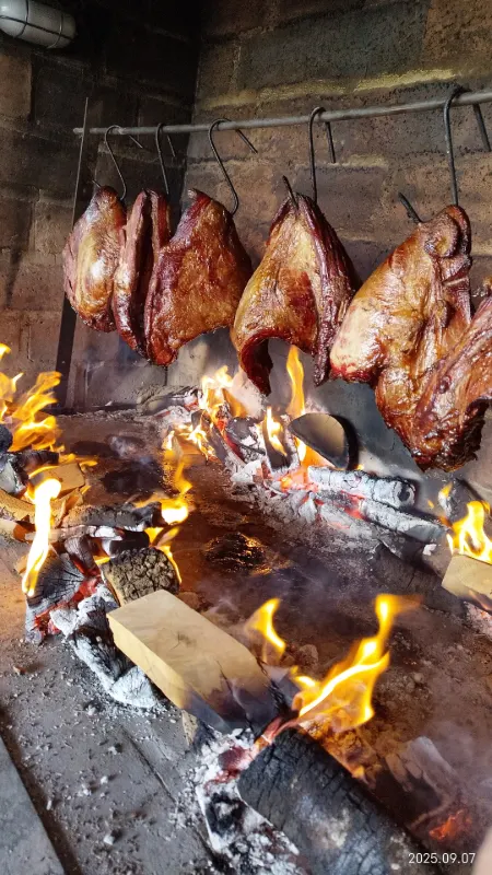 Carnes al gancho cocinándose a la llama