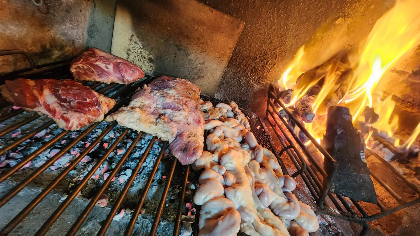 Parrilla con cortes y achuras sobre el fuego