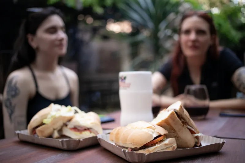 Invitadas disfrutando sándwiches de carne en una juntada